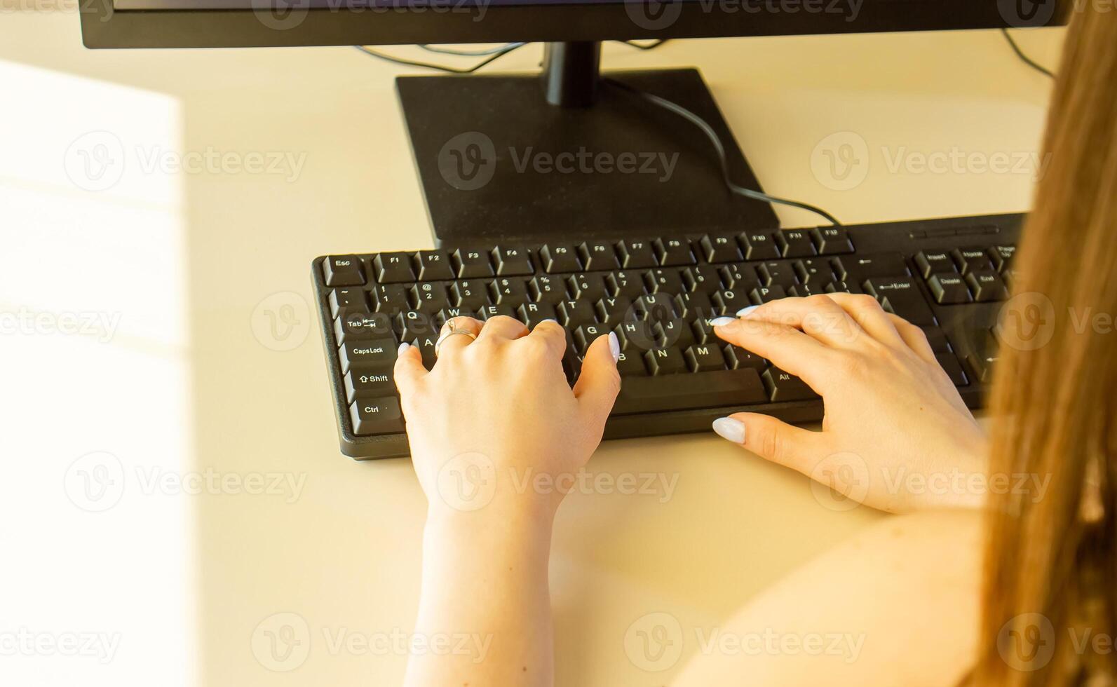 close up of hands typing on a laptop in office photo