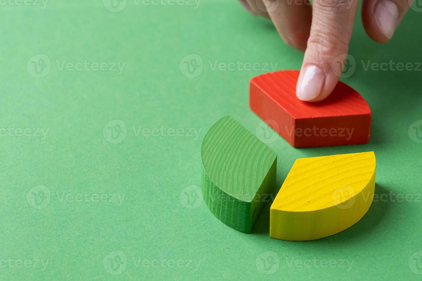 Colorful wooden pie chart pieces, hand adding piece of diagram photo