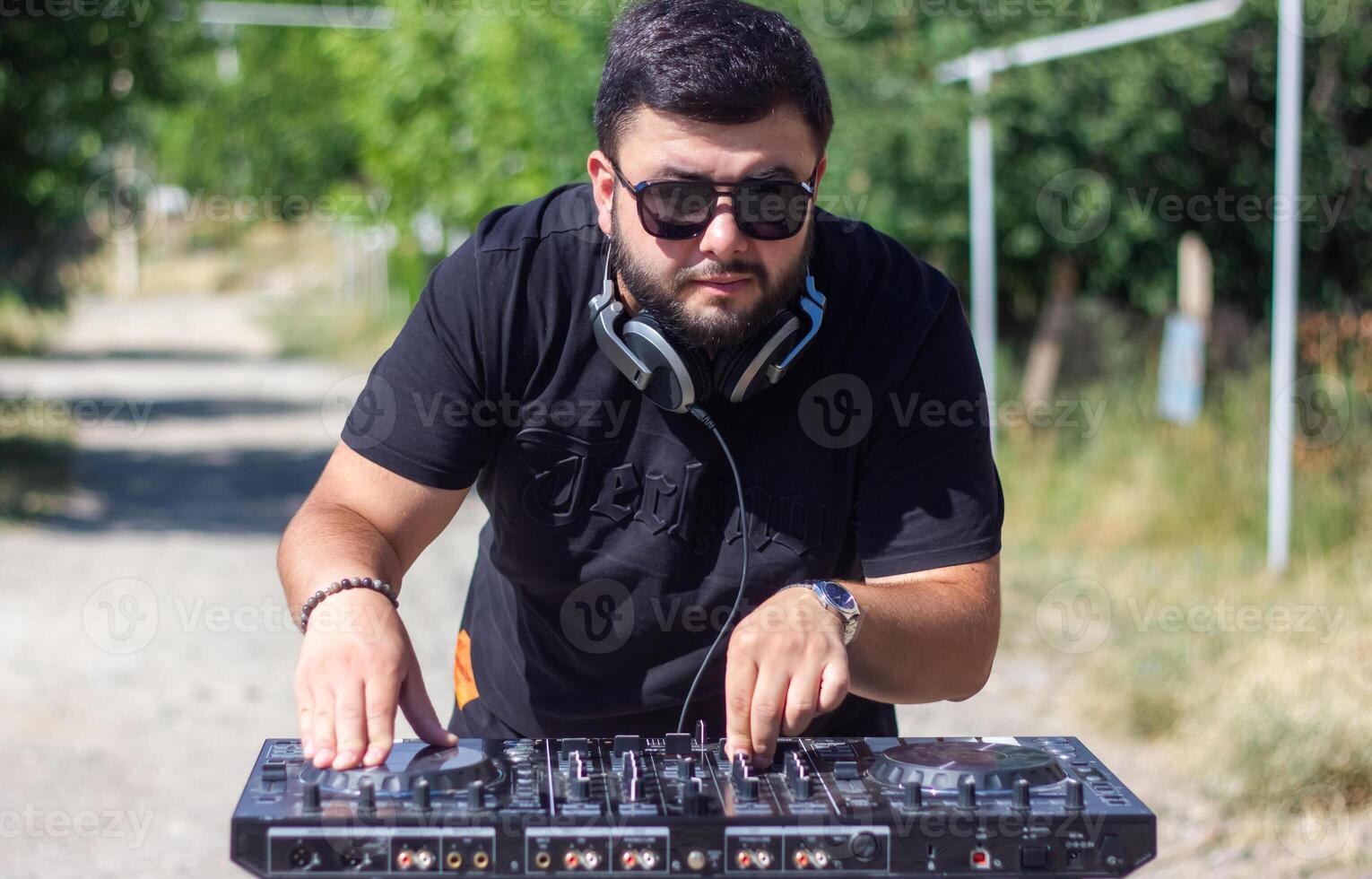 DJ con auriculares y mezclador en el parque, el DJ a trabajo foto