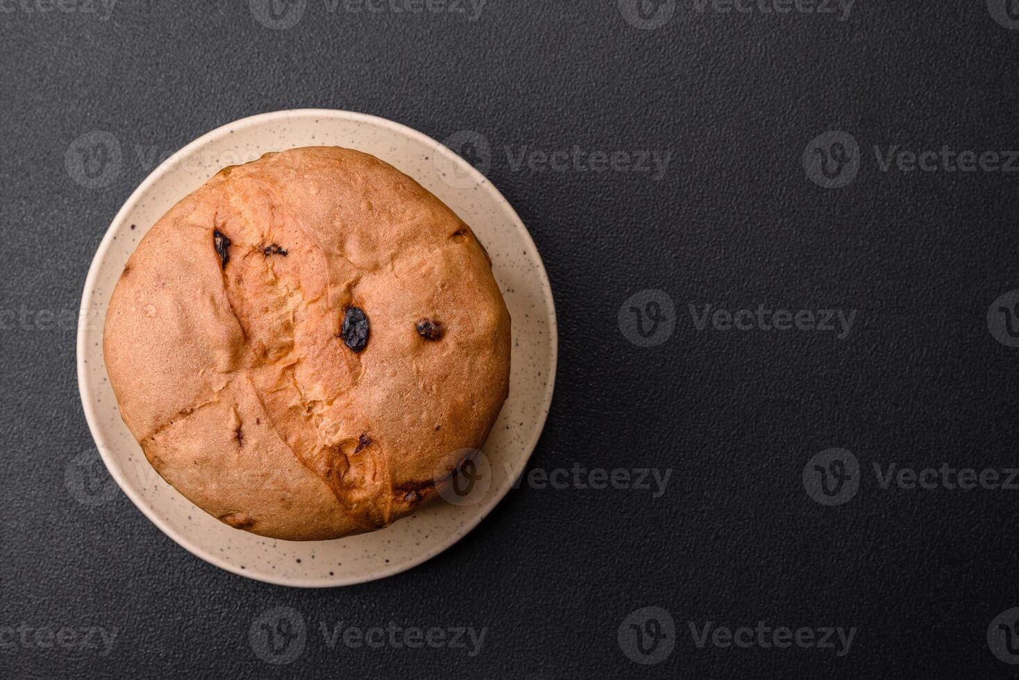 Delicious sweet holiday panettone cake with zest and raisins on a ceramic plate photo