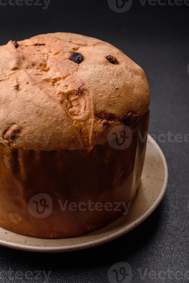 Delicious sweet holiday panettone cake with zest and raisins on a ceramic plate photo