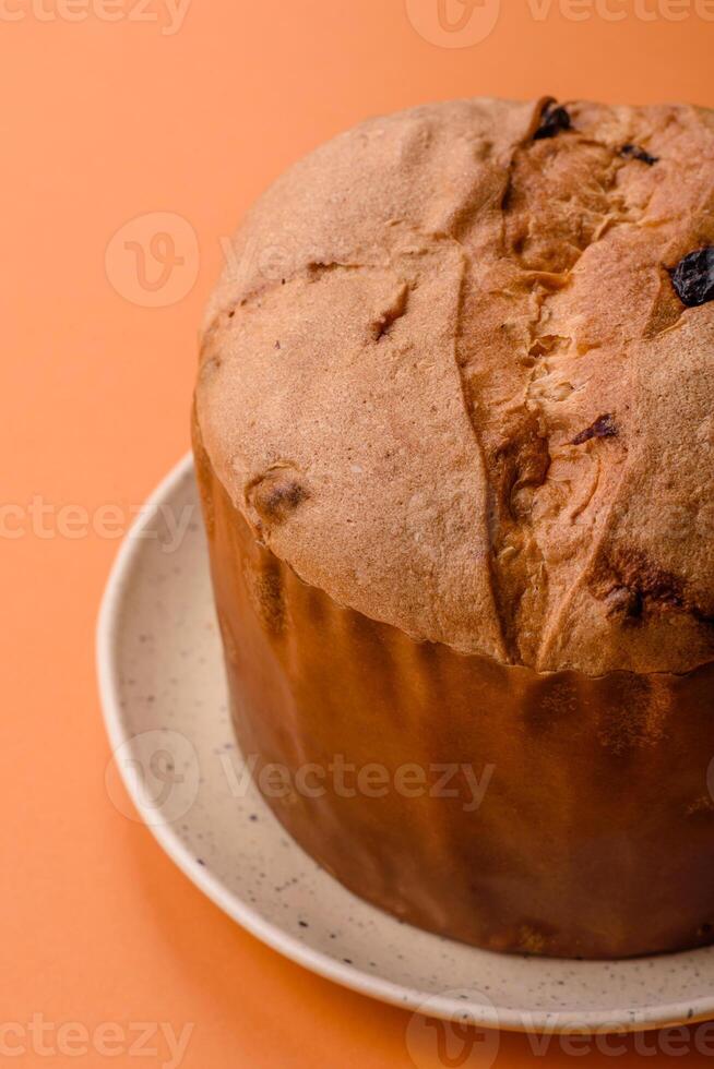 Delicious sweet holiday panettone cake with zest and raisins on a ceramic plate photo