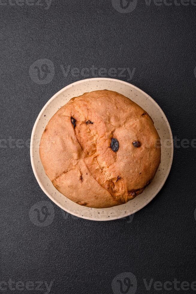 Delicious sweet holiday panettone cake with zest and raisins on a ceramic plate photo