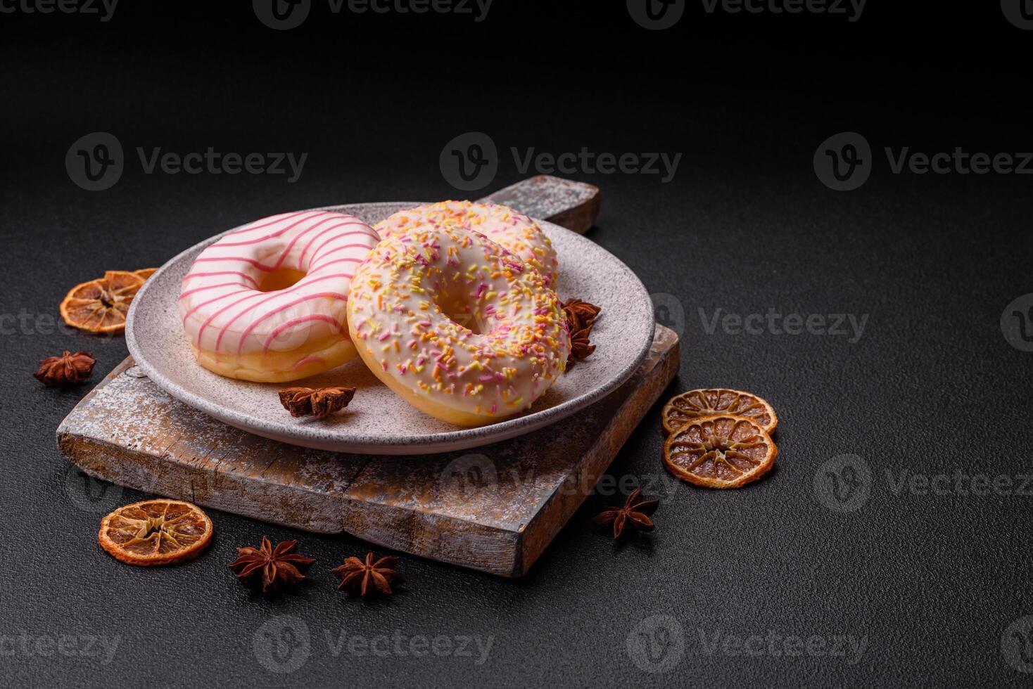 Delicious sweet bright donuts with cream on a plain background photo