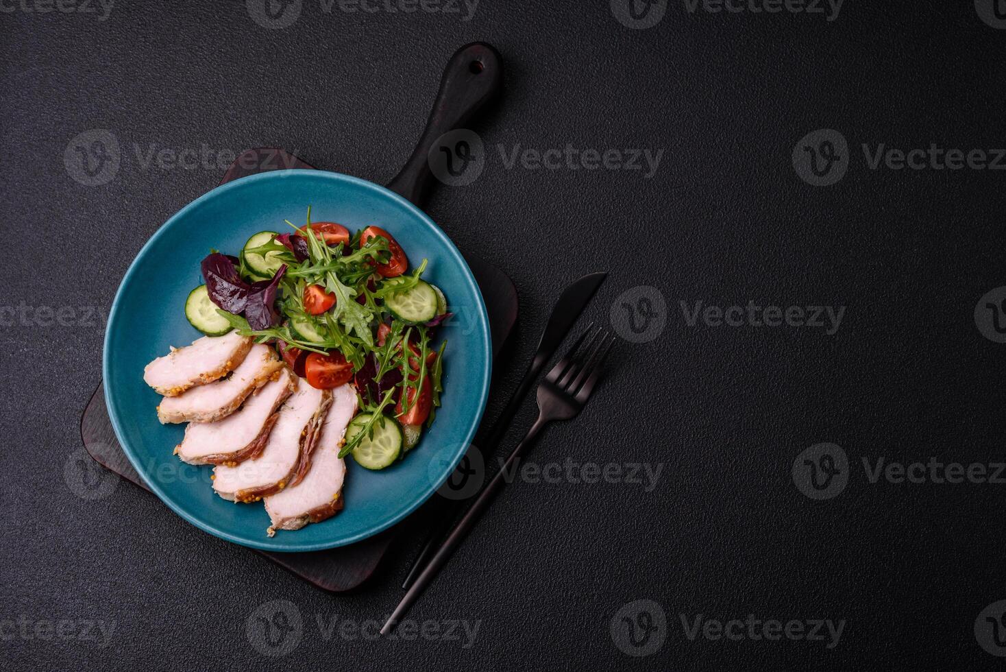 Delicious dietary salad with arugula, cucumber and cherry tomatoes and chicken breast slices photo