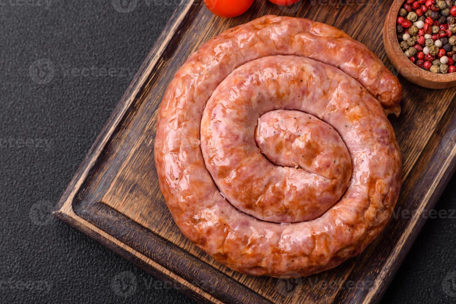 Delicious grilled sausage in the form of a ring with salt, spices and herbs photo
