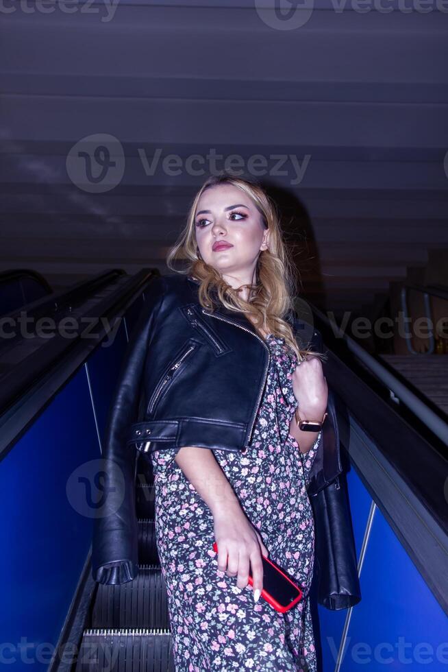 el hermosa joven mujer en el escalera mecánica foto