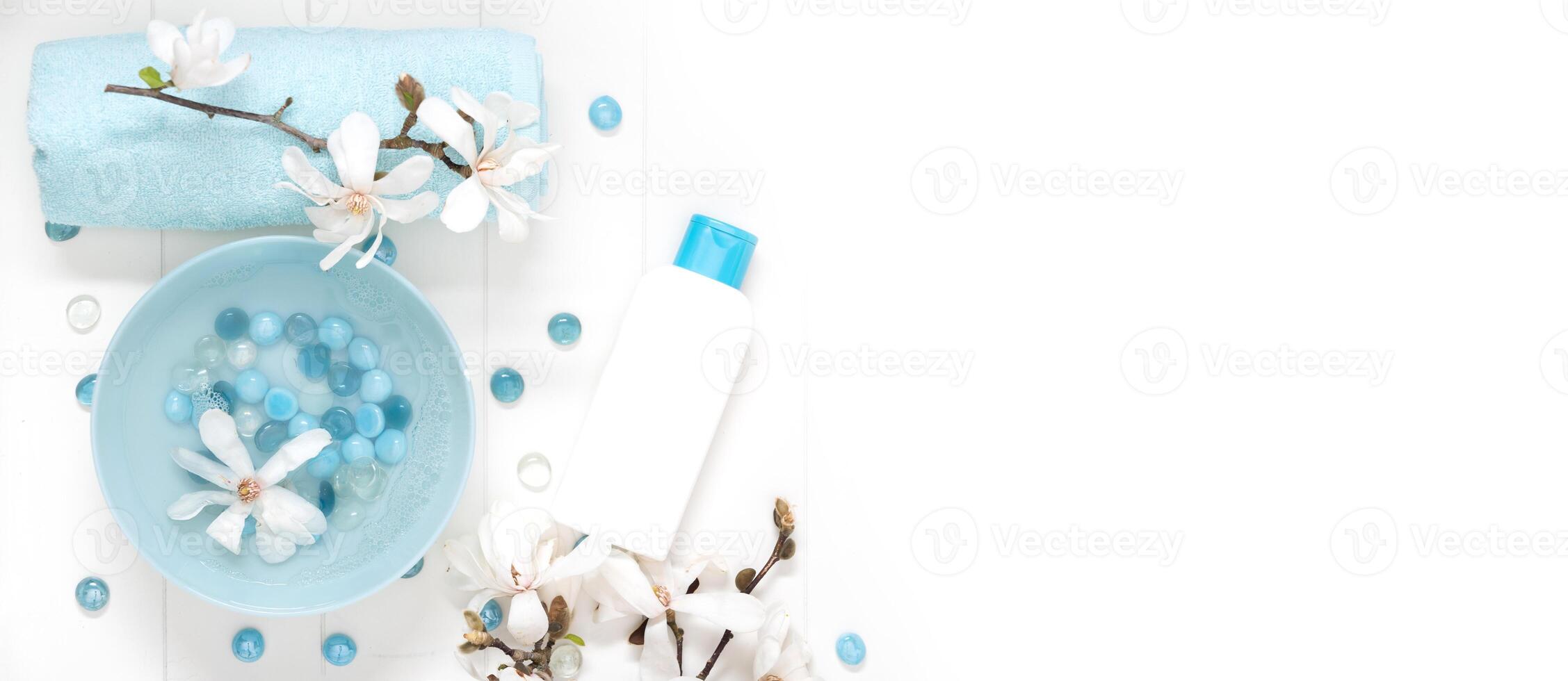 turquesa cuenco con agua y madre de perla spa piedras para amable manicura en el salón con blanco magnolia flores foto