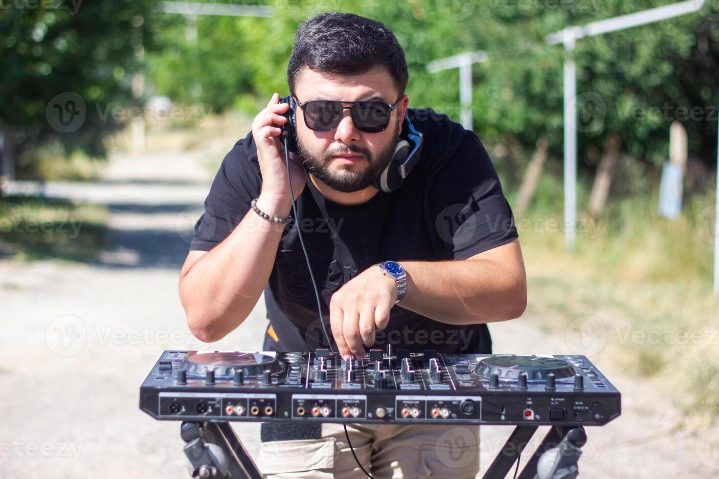 DJ con auriculares y mezclador en el parque, el DJ a trabajo foto