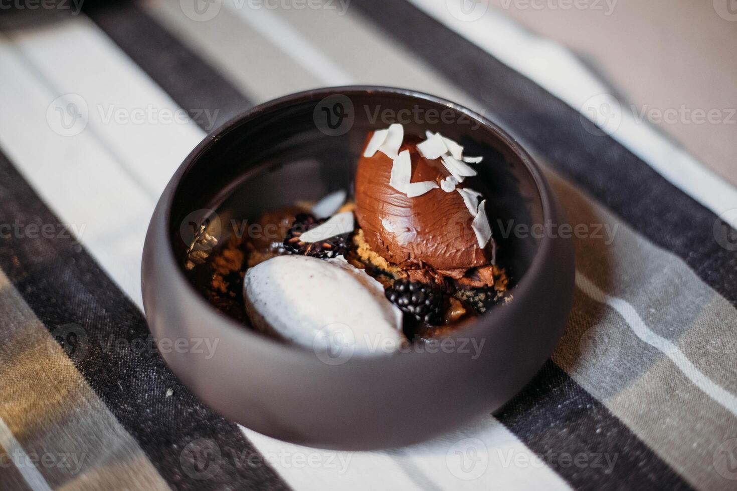 Chocolate ice cream in a bowl on a wooden table, selective focus photo