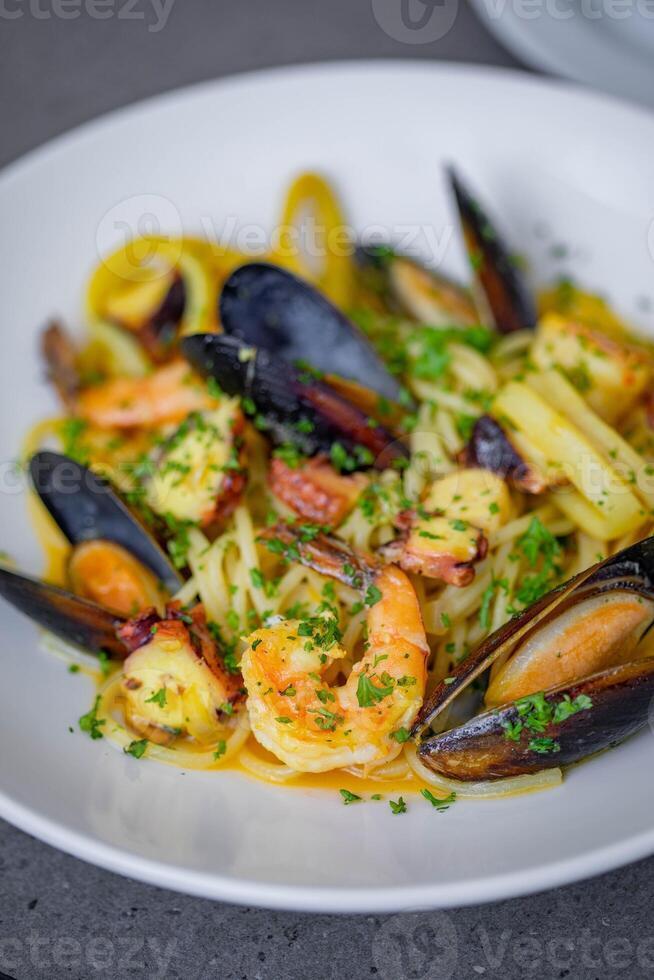Seafood pasta with prawns and mussels in white plate photo
