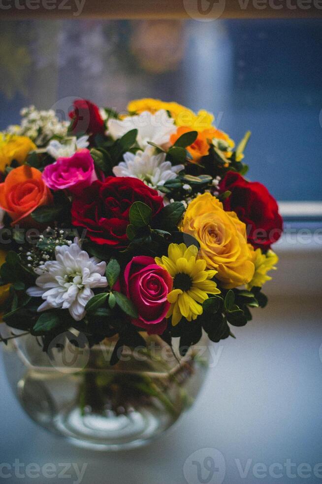 ramo de flores de flores en un florero en el antepecho foto