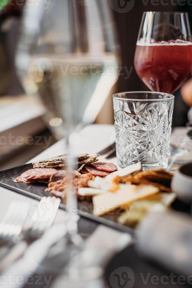 Catering service. Wine glass with red wine and snacks on the table photo