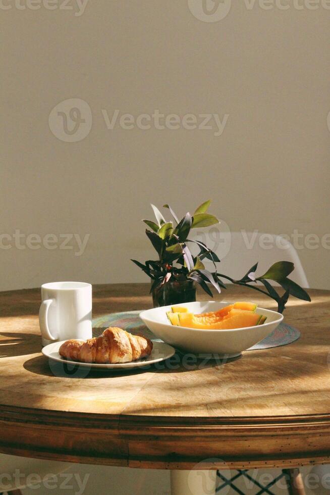 desayuno con café y croissants en mesa en Mañana ligero foto