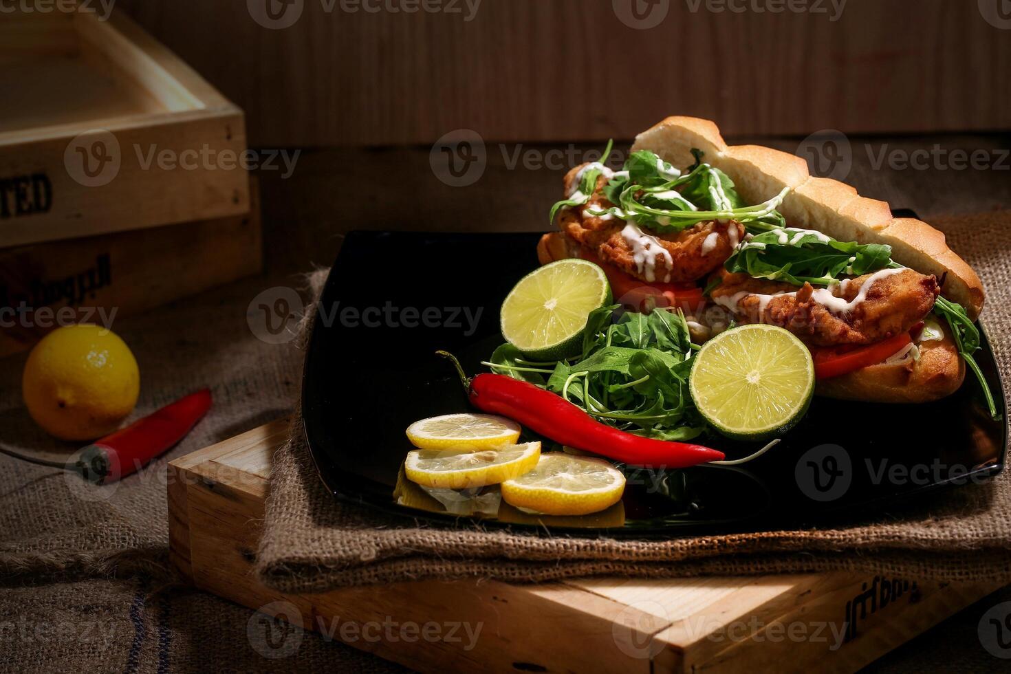 Hot dog with lime, arugula and chilli on wooden background photo