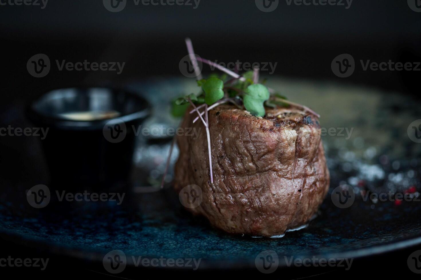 Beef steak with sauce on a blue plate. Selective focus. photo