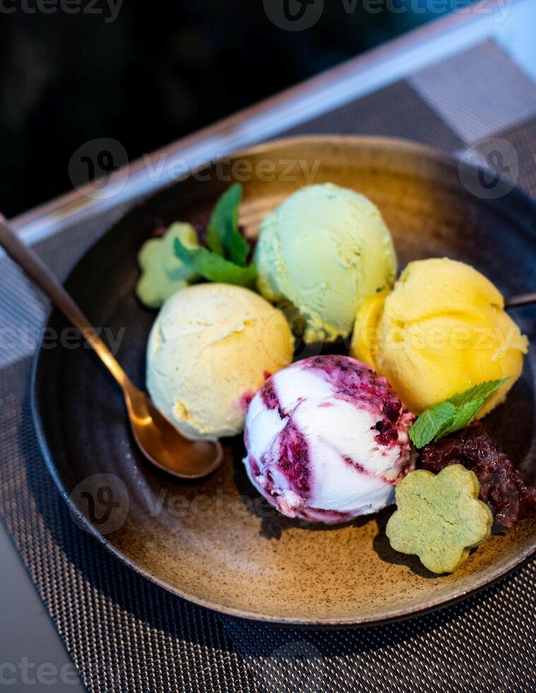 Ice cream scoops of different colors and flavours served on a plate photo