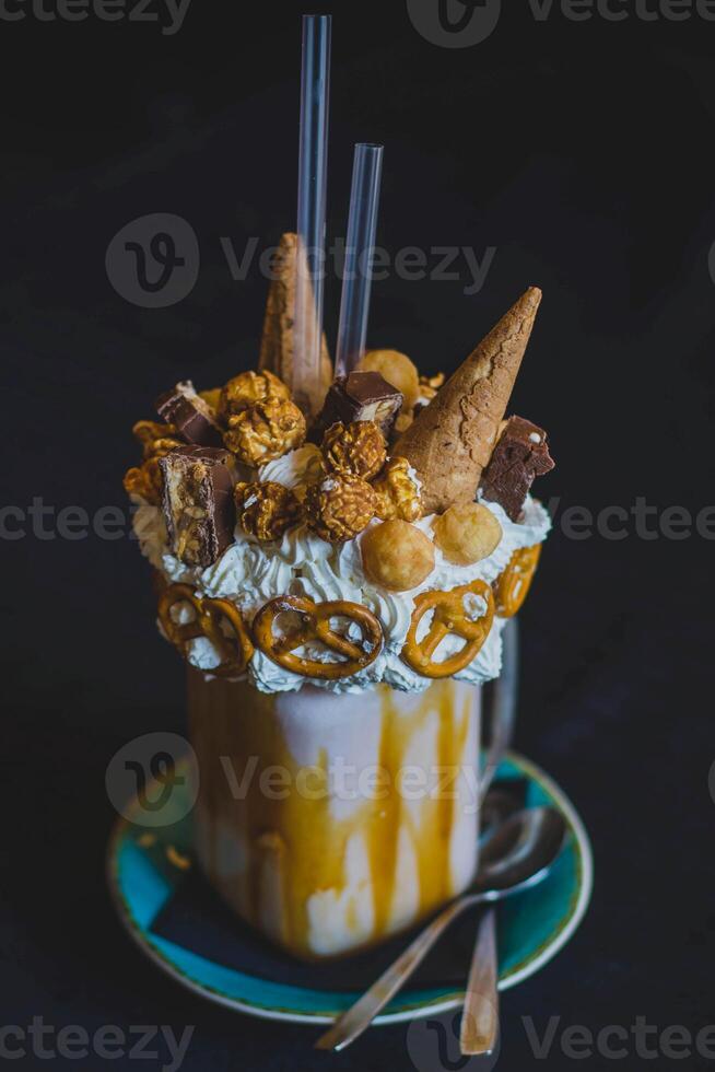 hielo crema con azotado crema y nueces en un taza en negro antecedentes foto