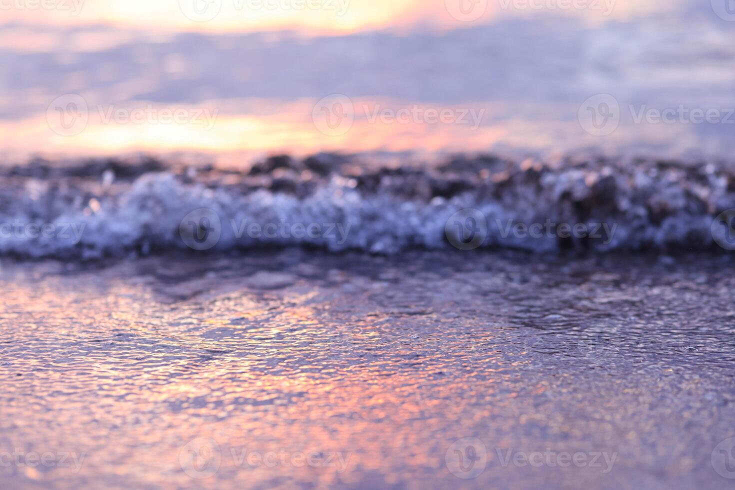 Soft wave of the sea on the sandy beach at sunset. Selective focus. photo