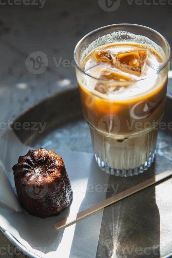 Iced coffee with ice cubes and chocolate cake on the table. photo