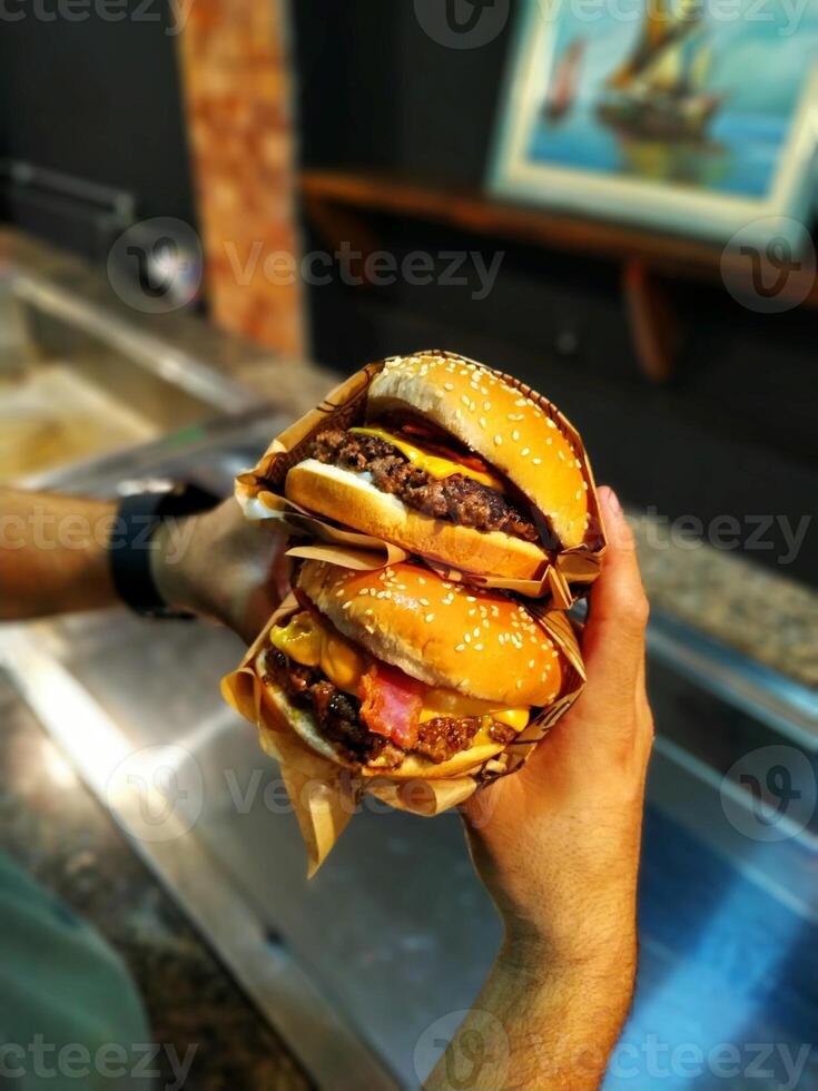hamburguesa en el manos de un hombre. calle comida concepto. foto