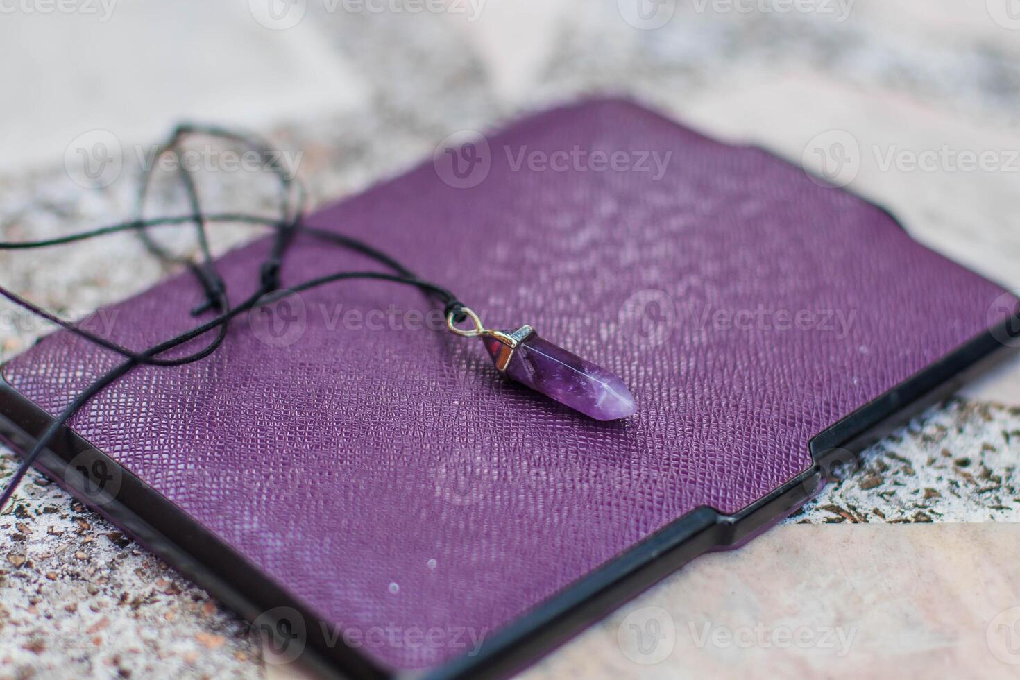 Purple earrings on a book. Accessories for meditation and relaxation. photo