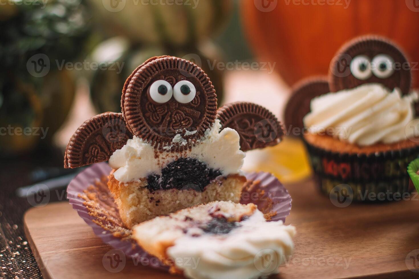 Halloween cupcakes with funny monsters on wooden table. Halloween party photo