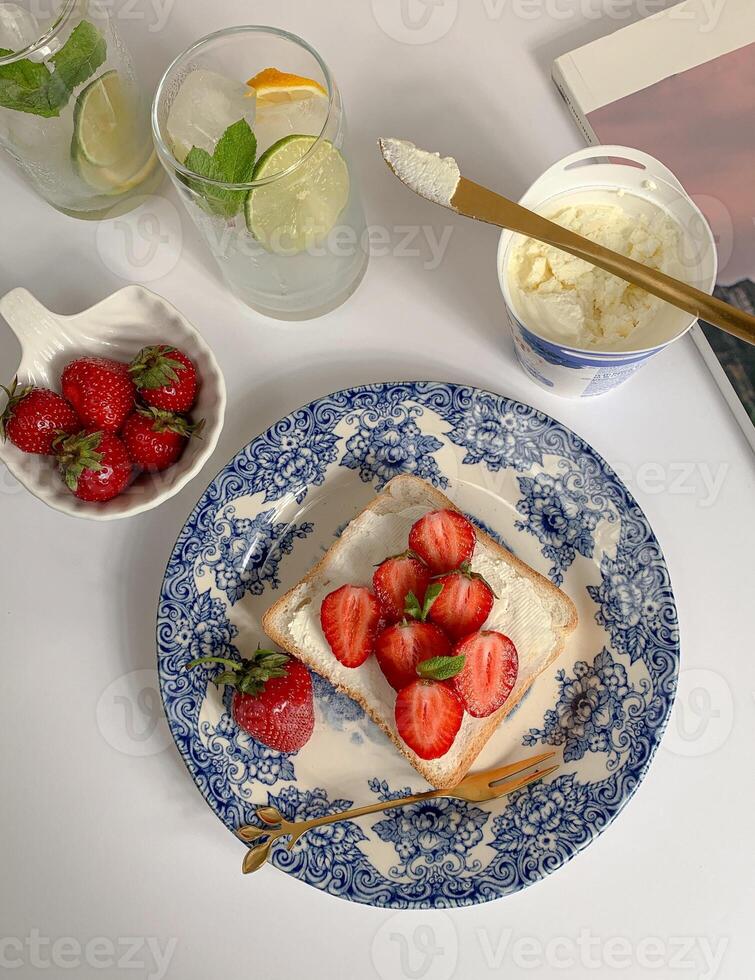 Healthy breakfast with toast bread, strawberries, lime and ice cream photo