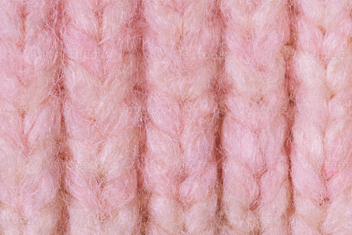 Terry knitted texture as a macro photo background. Pink and beige detail of a knitted item.