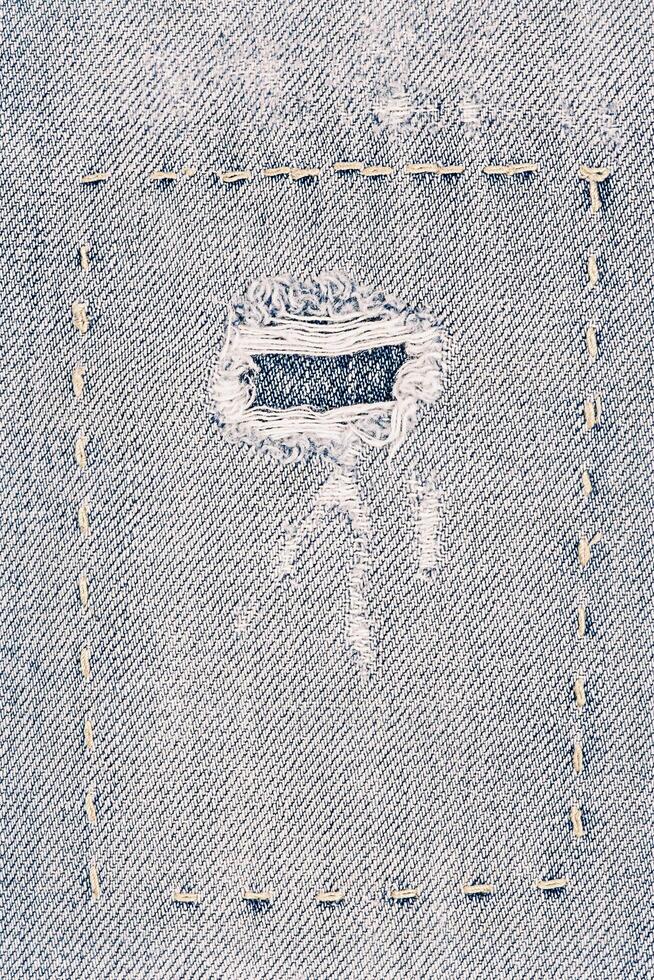 Denim fabric as a background. Macro photo of an item of clothing, jeans with a patch.