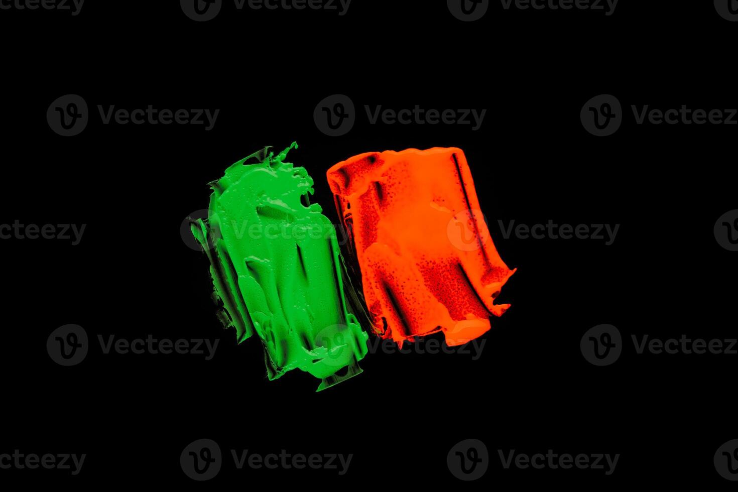 Green orange color paint splotches on black background photo