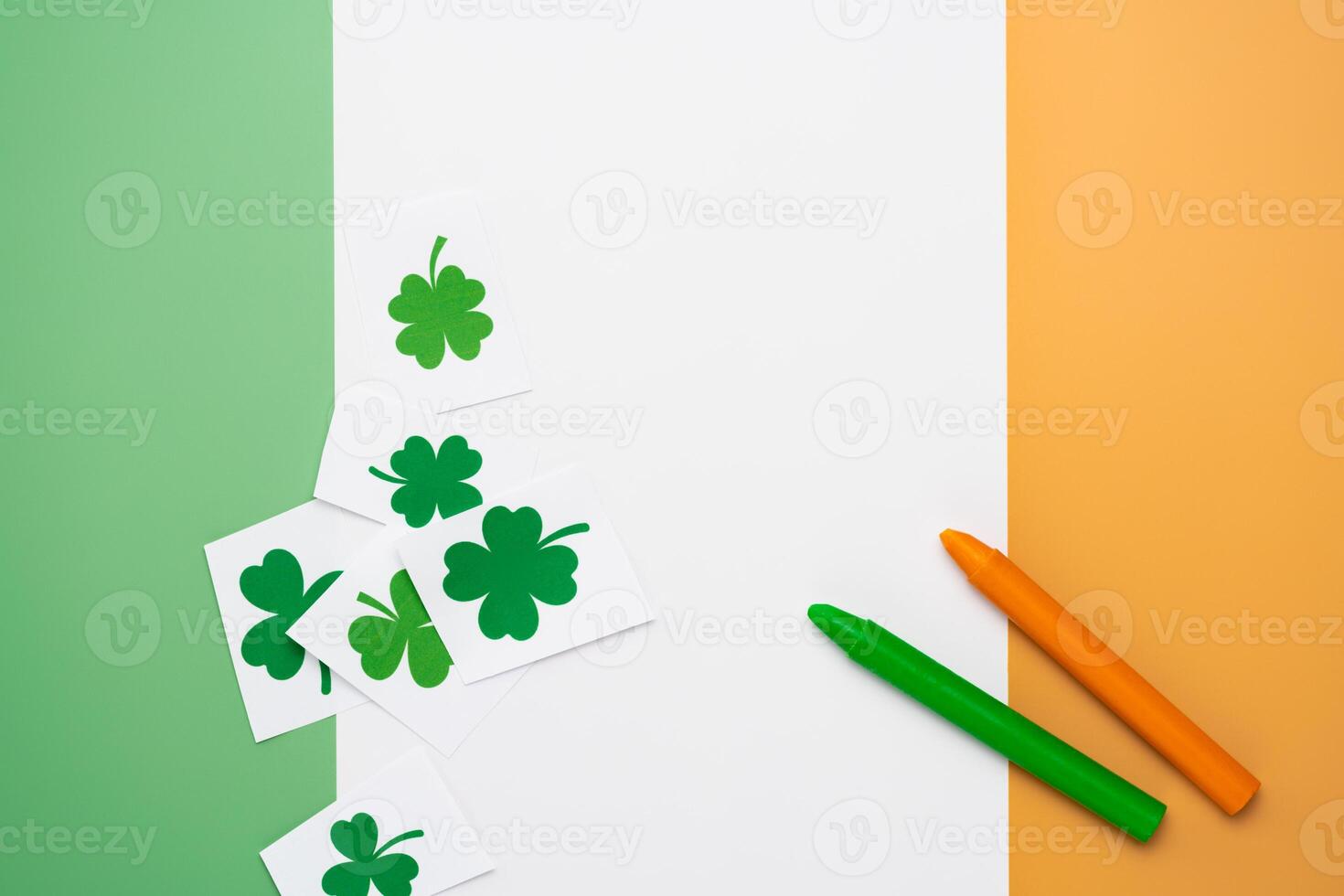 Irish flag made from color paper with cut out shamrock clover and crayons photo