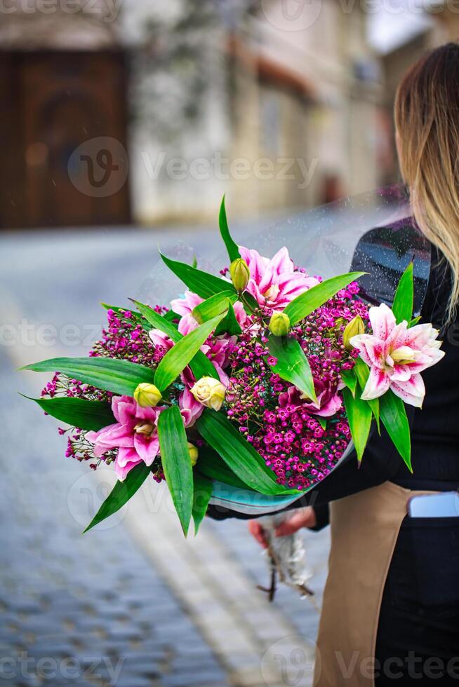 Woman Walking Down Street With Bouquet of Flowers photo