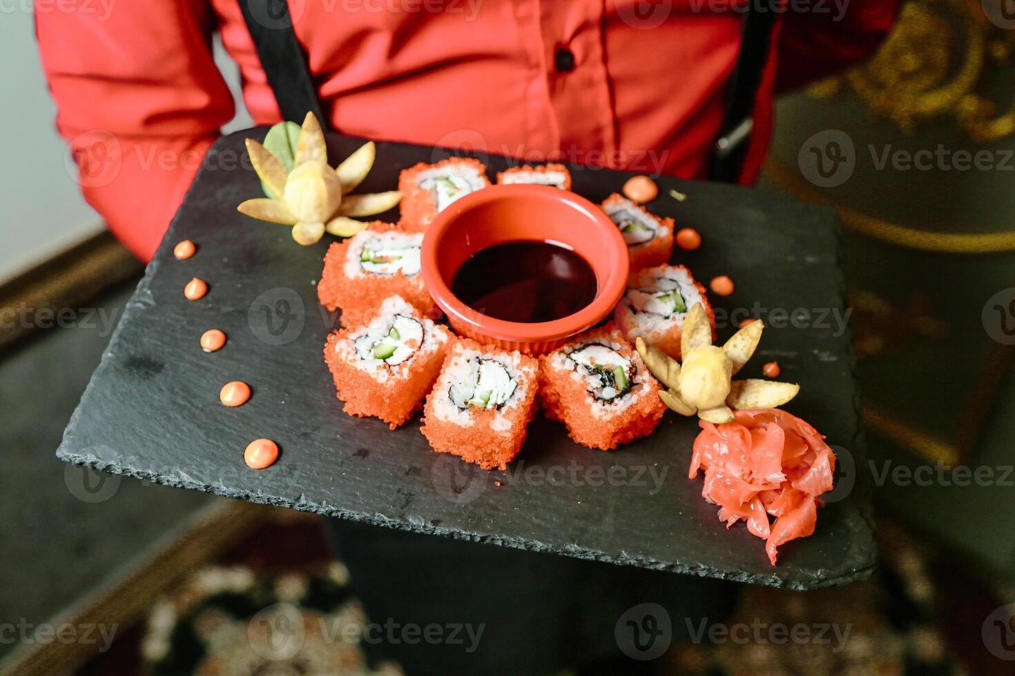 persona participación bandeja con Sushi a un restaurante mostrador foto