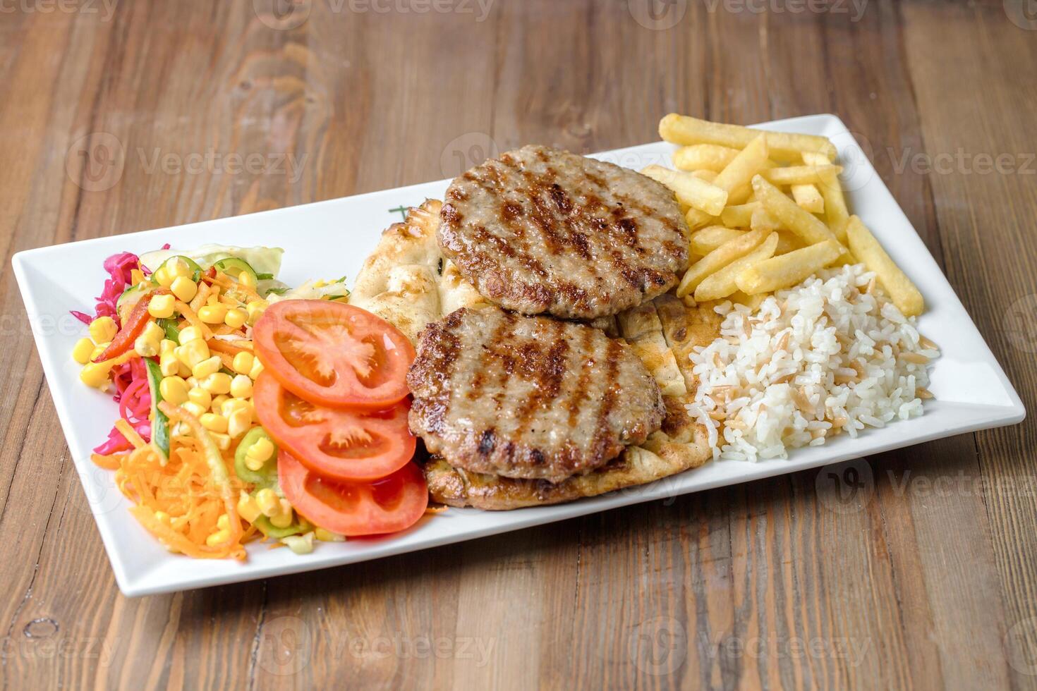 Plate With Meat, Fries, and Vegetables on White Background photo