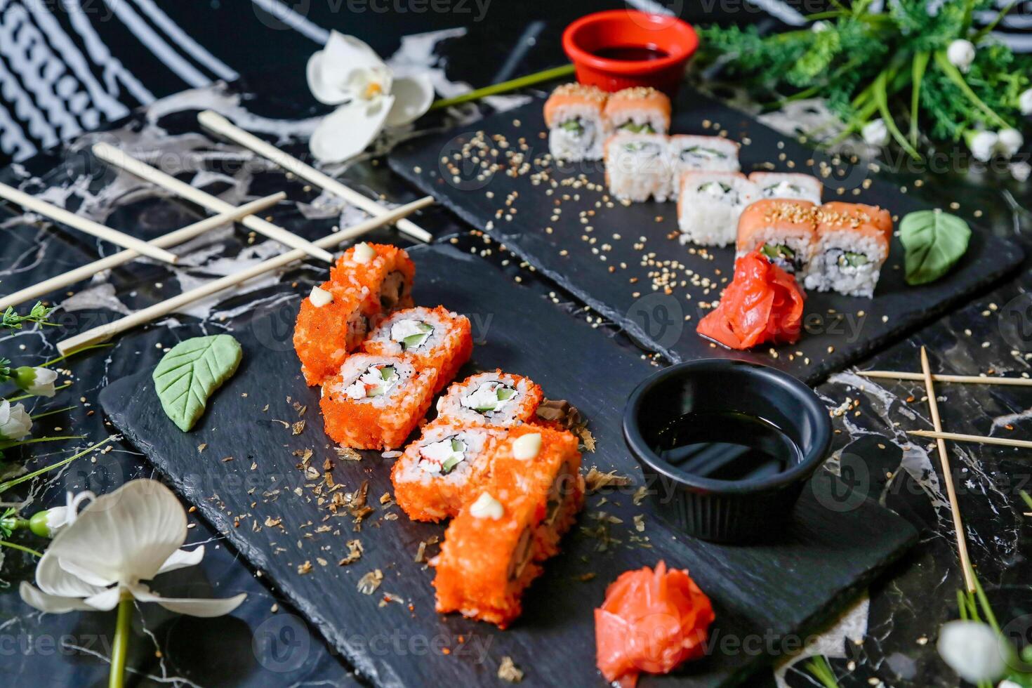 Sushi on a Black Plate With Chopsticks and Flowers photo