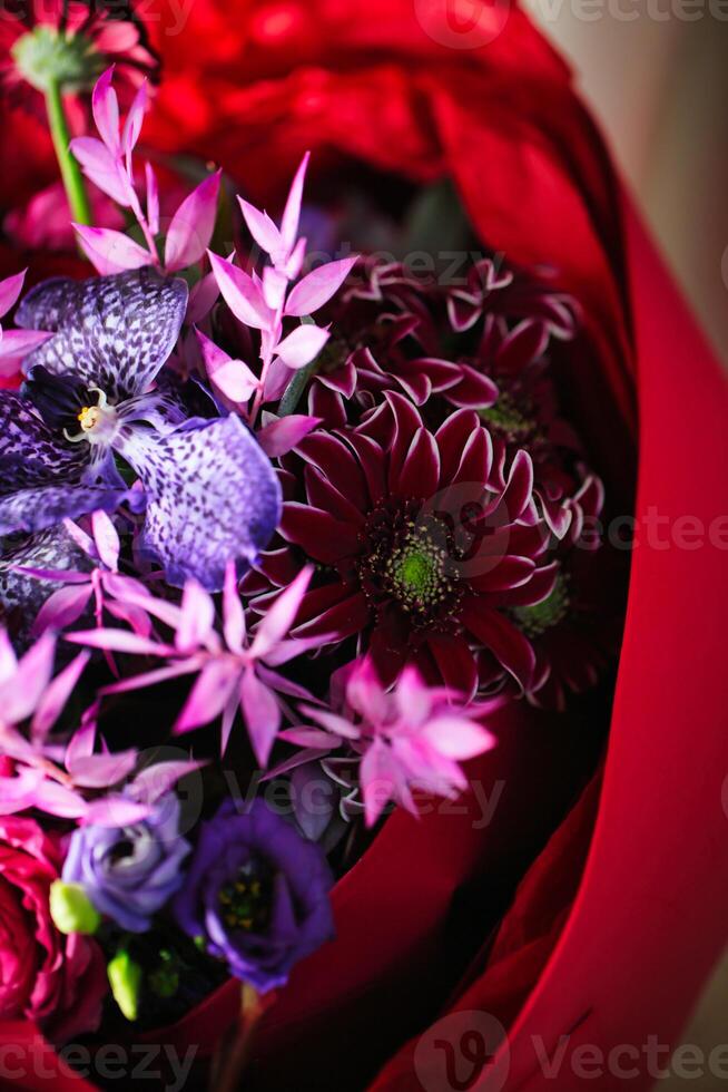vibrante púrpura y rojo ramo de flores en rojo envolver foto