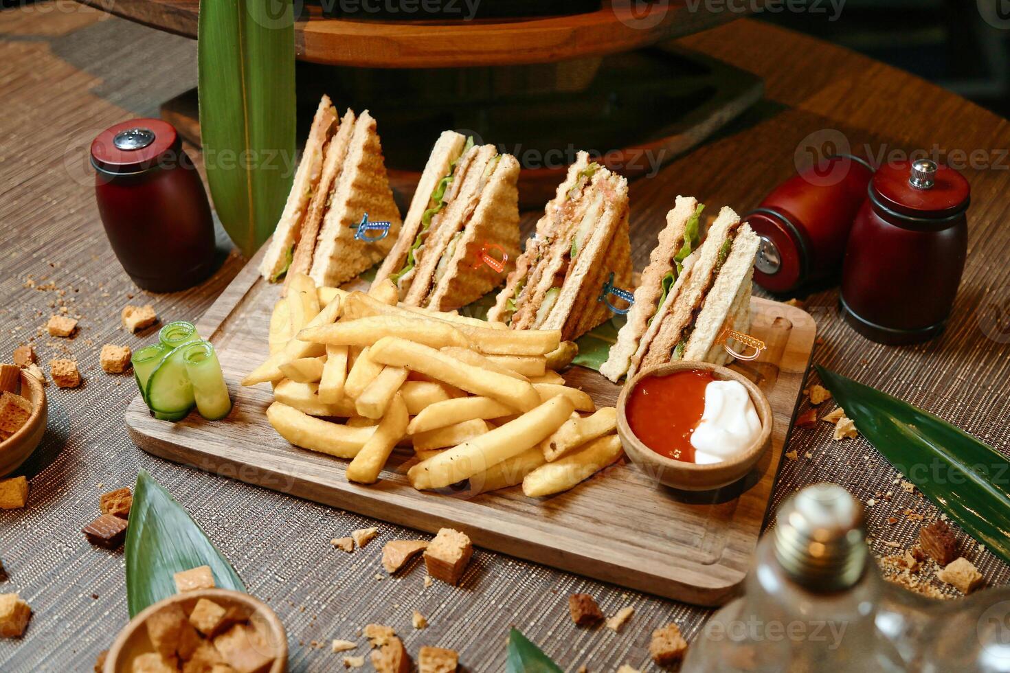 Wooden Cutting Board With a Half Sandwich and French Fries photo
