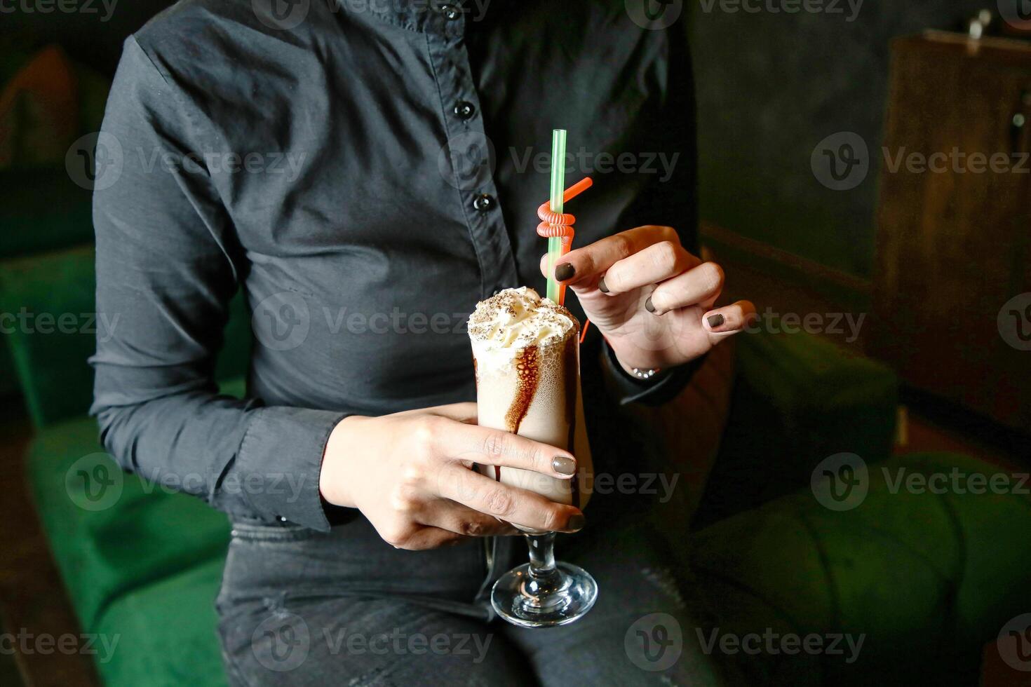 Woman Sitting on Green Couch Holding Drink photo