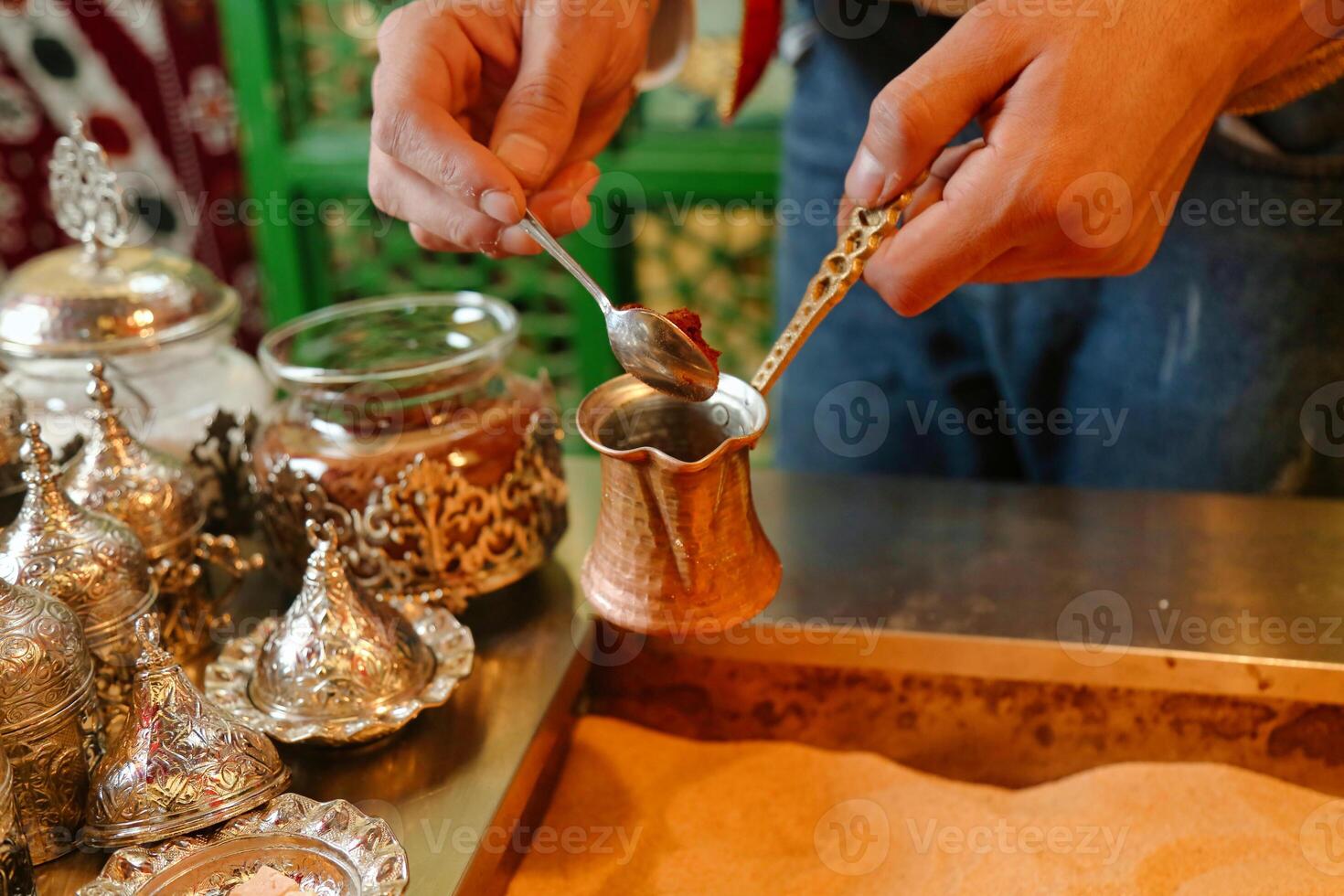 Person Holding a Spoon Over a Metal Cup photo