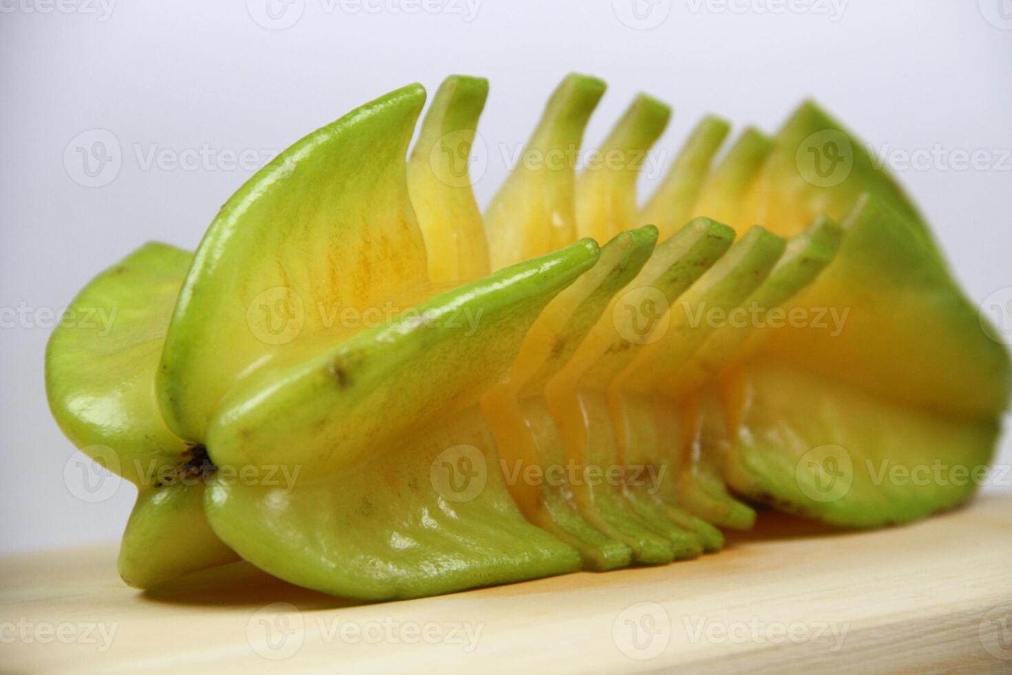 slices of starfruit well arranged on wooden cutting board photo