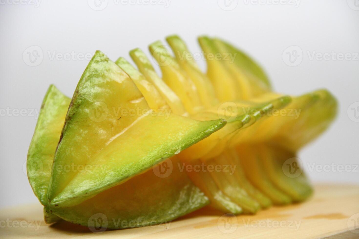 slices of starfruit well arranged on wooden cutting board photo