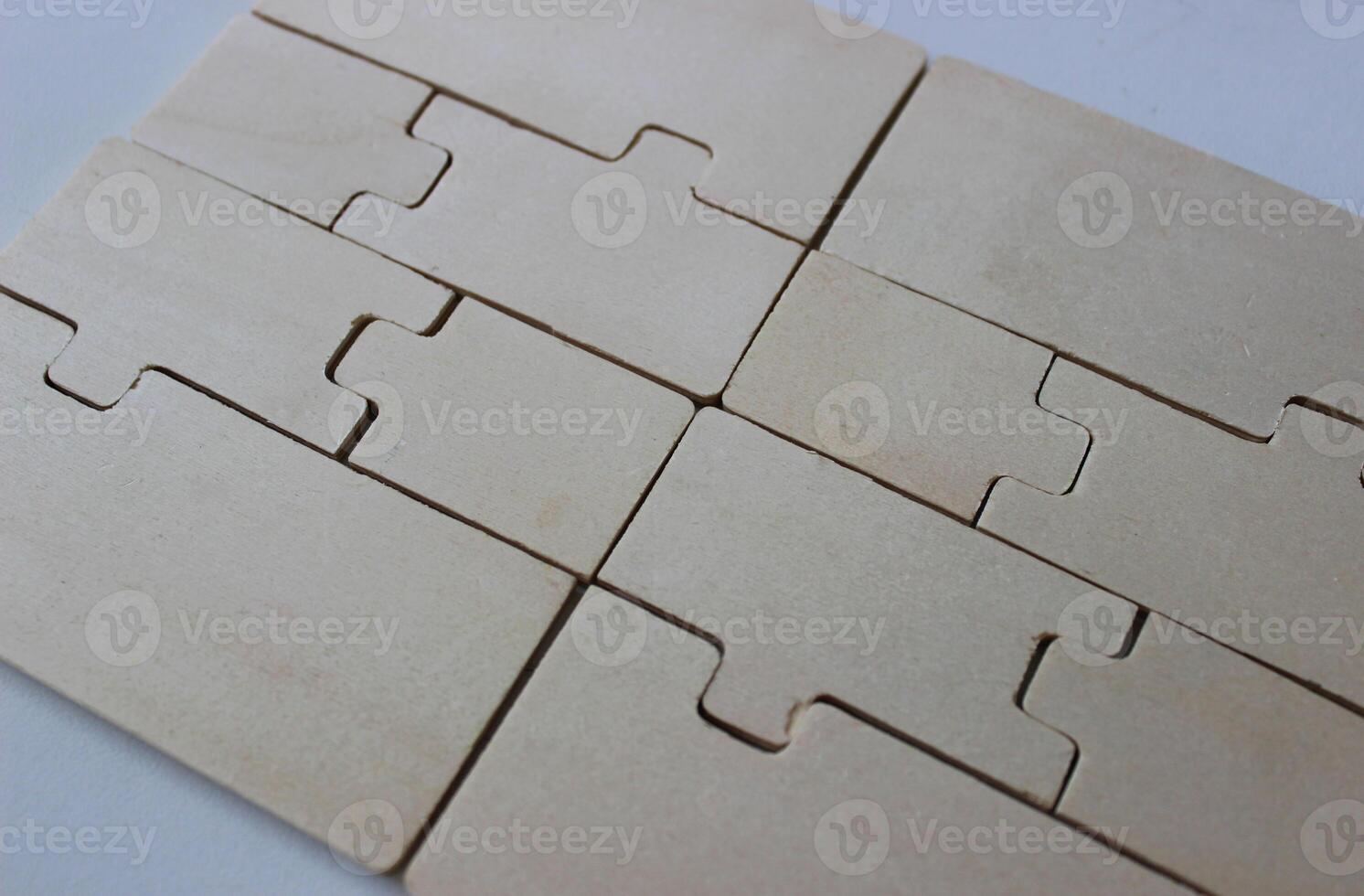 Rectangular panel of tightly folded plywood puzzles on a white surface photo