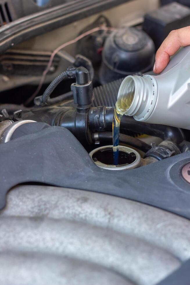 Motor oil pouring to car engine photo