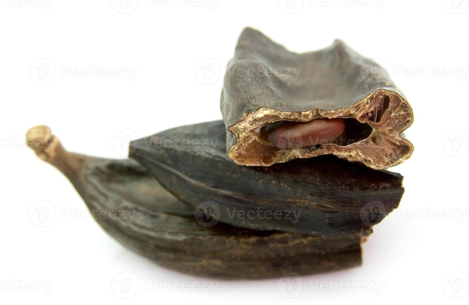 Cut carob pods on white backgrounds photo