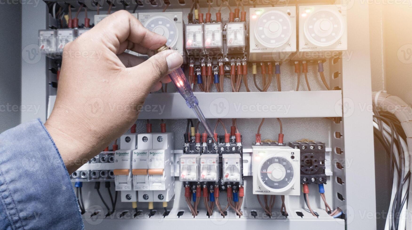 comprobación el eléctrico poder en el controlar panel utilizando un prueba bolígrafo. foto