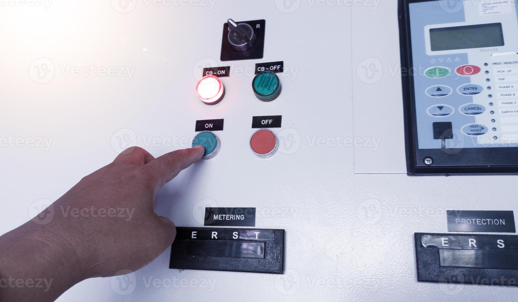 The Technician setting the parameter of the Over Current Rellay on control cubicle panel. photo