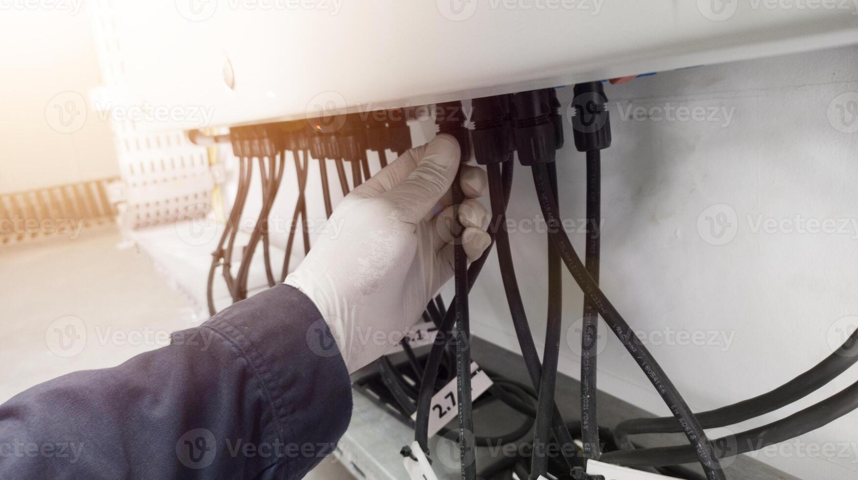 A engineering checking power cable lines in inverter solar panel. photo