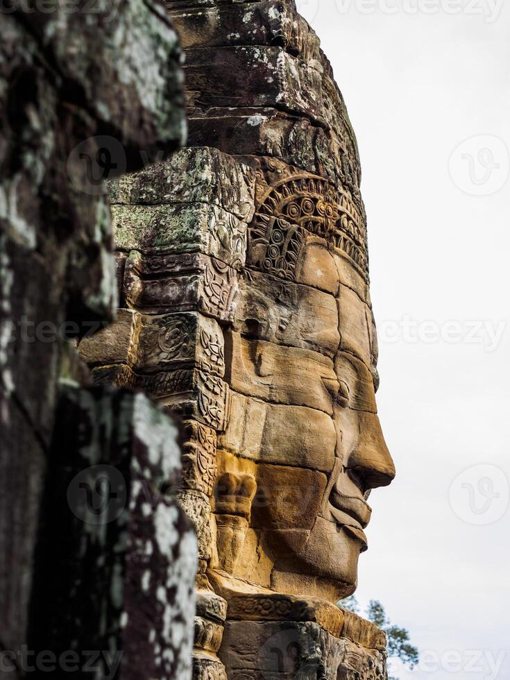 antiguo Roca tallado cara a bayon templo en siem recoger, Camboya foto