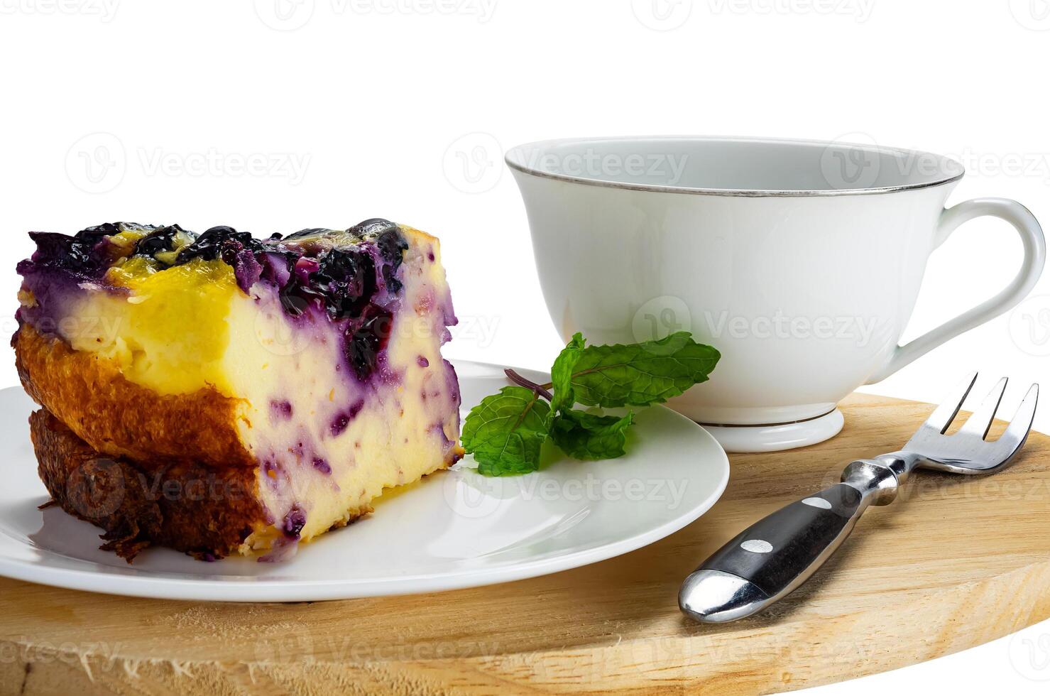 Closeup view slice of yogurt blueberry cake in white ceramic dish with a cup of coffee and metal fork isolated on white background with clipping path. photo